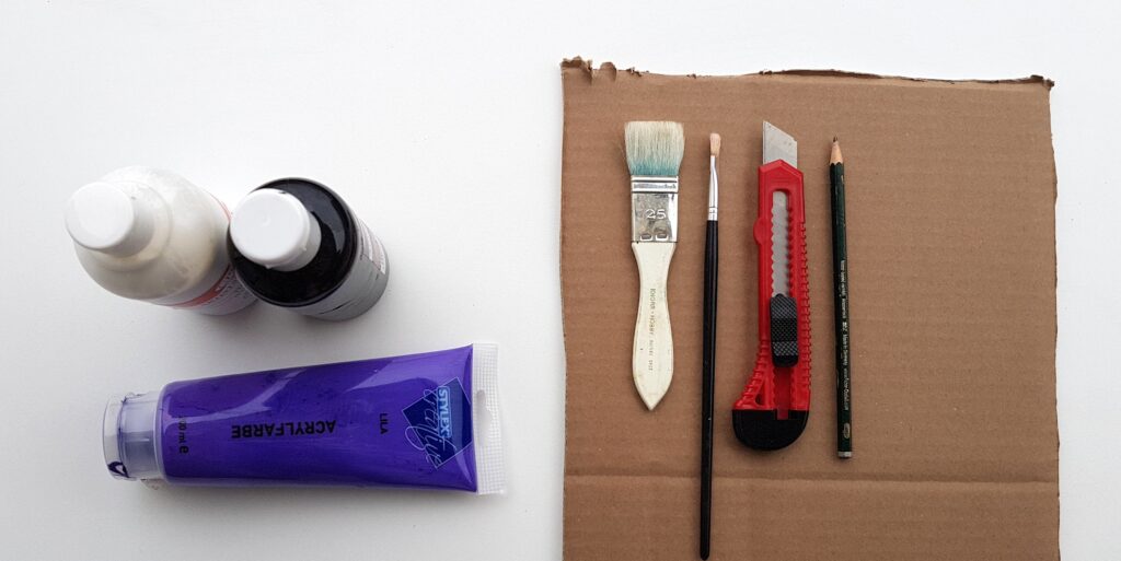 Bastelutensilien: Pinsel, Bleistift, Cuttermesser, Farbe, Unterlage
